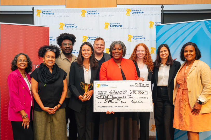 Group holding the Philadelphia Startup World Cup first-place award check in front of a City of Philadelphia backdrop